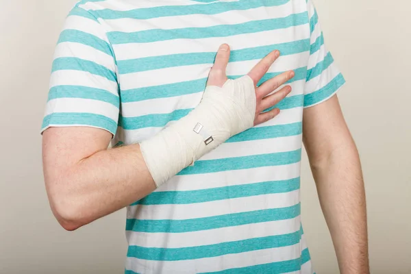 Del kropp man med bandagerade hand. — Stockfoto