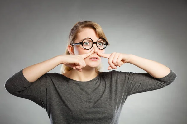 Girl pinches her nose because of stench stink. — Stock Photo, Image