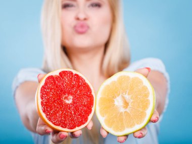 Kırmızı ve yeşil greyfurt tutan kadın