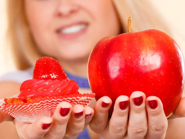 Kadın elma ve tatlı çörek arasında seçim yapma — Stok fotoğraf