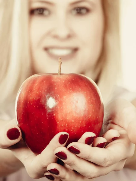 Happy woman holding delicious red apple — Stock Photo, Image