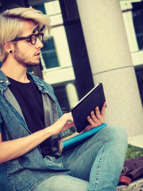 Hipster adam kenarında oturan tablet ile