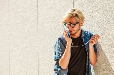 Kulaklık aracılığıyla müzik dinleme gülümseyen hipster adam