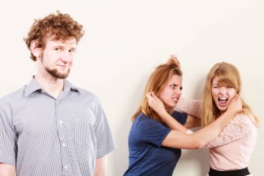 Aggressive mad women fighting over man. clipart