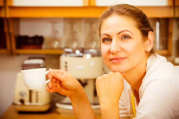 Ältere Frau hält Tasse Kaffee in Küche. — Stockfoto