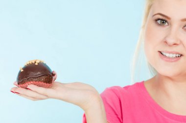 Çikolatalı kek tutan kadın ısırmak üzere.