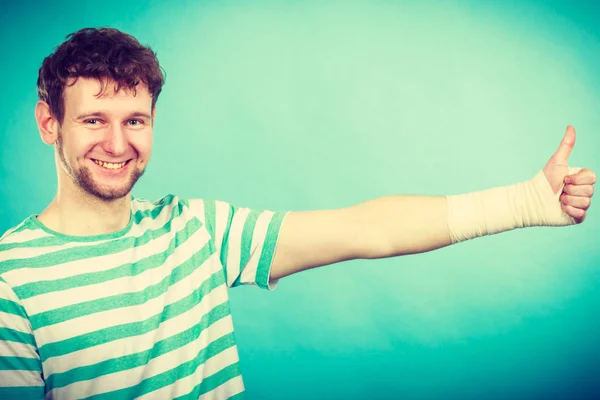 Hombre con la mano vendada mostrando el pulgar hacia arriba . — Foto de Stock