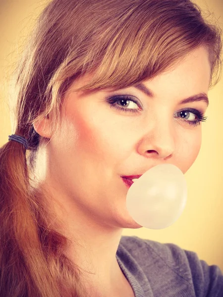 Chica rubia masticando chicle haciendo globo . — Foto de Stock