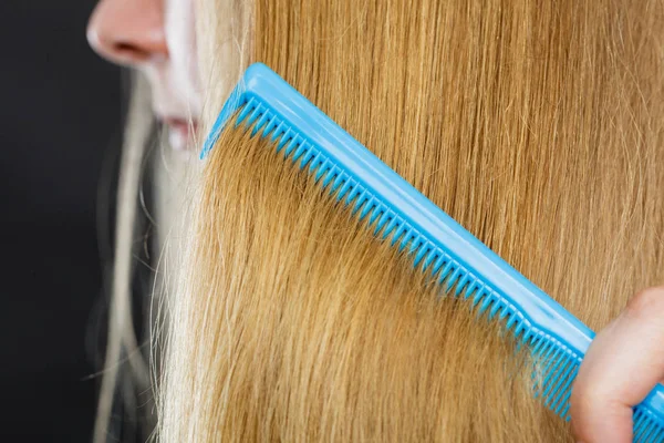 Nahaufnahme von blauem Kamm im blonden Haar. — Stockfoto