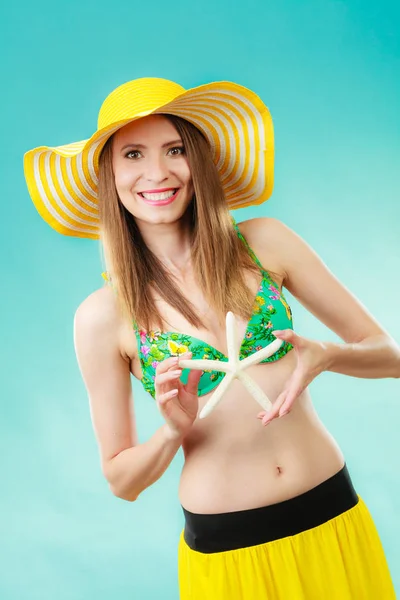 Vrouw in geel hoed bedrijf witte schelp — Stockfoto