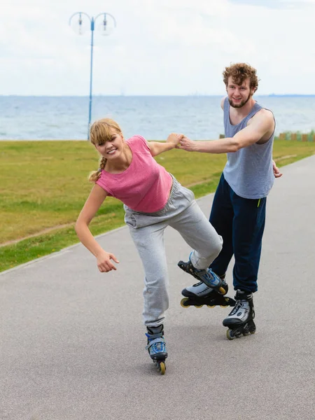 Mujer animar al hombre a hacer patinaje — Foto de Stock