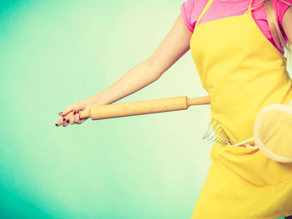 Mujer usando delantal sosteniendo colador y rodillo — Foto de Stock