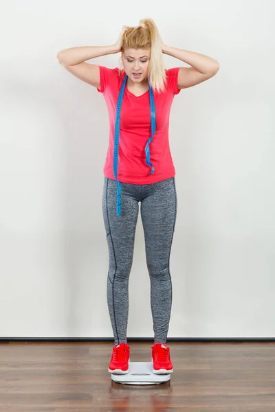 Kvinna som bär sportkläder stående på vikt maskin — Stockfoto