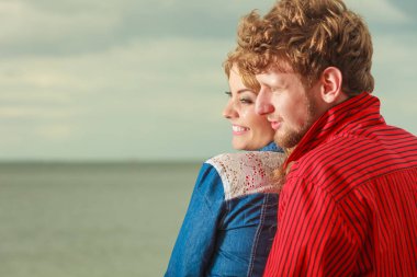 Deniz kıyısında çift oturma sarıldı