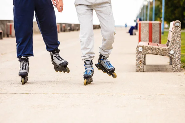 Freunde draußen haben Spaß beim gemeinsamen Inlineskaten. — Stockfoto