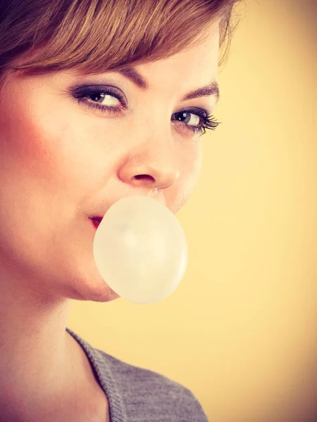 Chica rubia masticando chicle haciendo globo . — Foto de Stock
