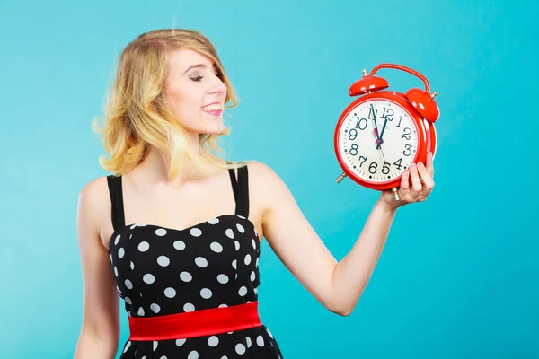 Lächelndes Mädchen mit Wecker auf blau. — Stockfoto