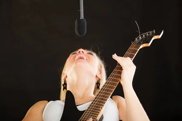 Жінка грає на електрогітарі та співає — стокове фото