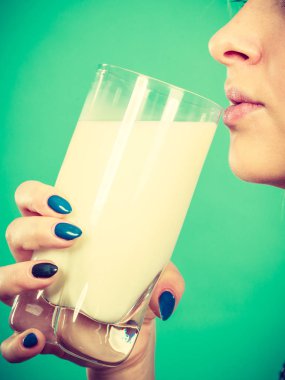 Kadın bardaktan süt içiyor.