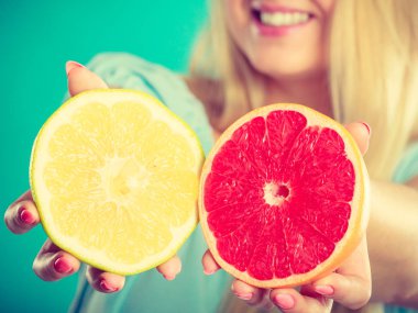 Kırmızı ve yeşil greyfurt tutan kadın