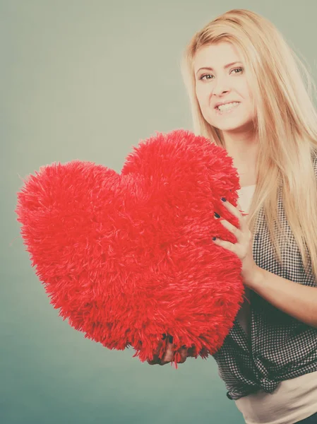 Happy woman holding red pillow in heart shape Royalty Free Stock Photos