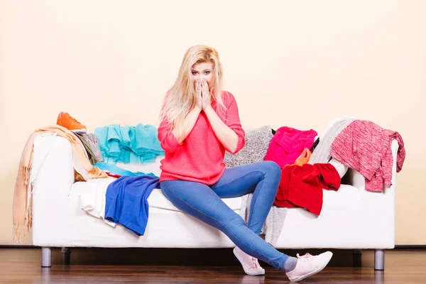 Woman does not know what to wear sitting on couch — Stock Image Woman does not know what to wear sitting on couch Royalty Free Stock Photos