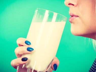 Kadın bardaktan süt içiyor.