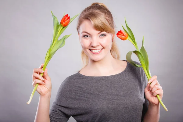 Glückliche blonde Frau mit Frühlingsblume. — Stockfoto