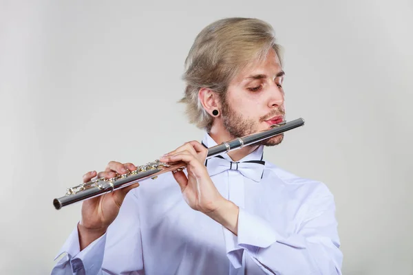 Мужской флейтист играет на флейте — стоковое фото