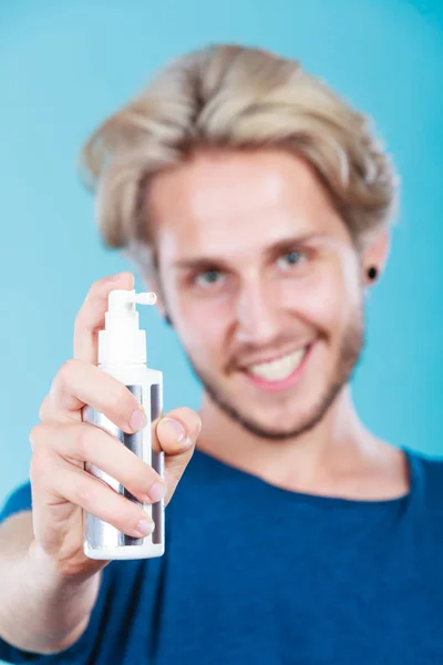 Man op zijn haar spray cosmetische toe te passen — Stockfoto