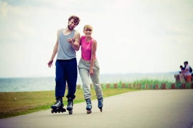 Genç bir çift paten yaparken elele