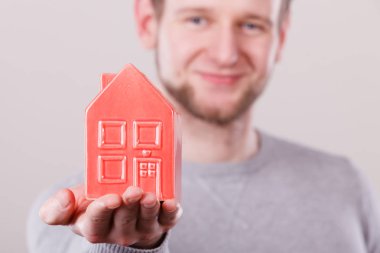 Genç adam evin üstünde palmiye holding.