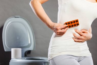 Woman suffer from belly pain holds pills in toilet clipart