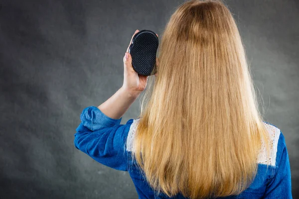 Mujer rubia peinándose el pelo . — Foto de Stock