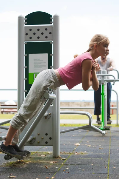 Aktive Frau trainiert auf dem Rückentrainer im Freien. — Stockfoto
