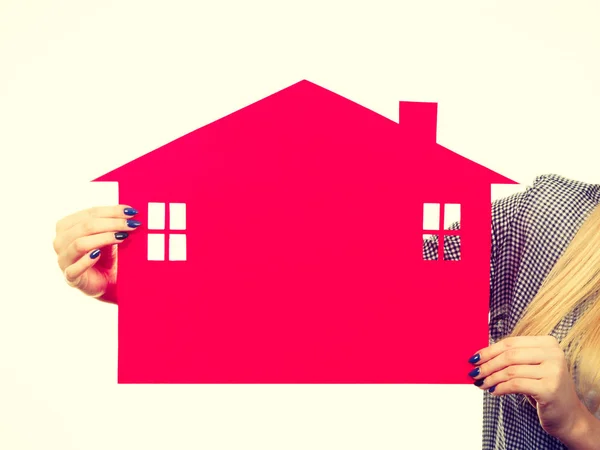 Kvinnliga handen håller rött papper hus symbol — Stockfoto