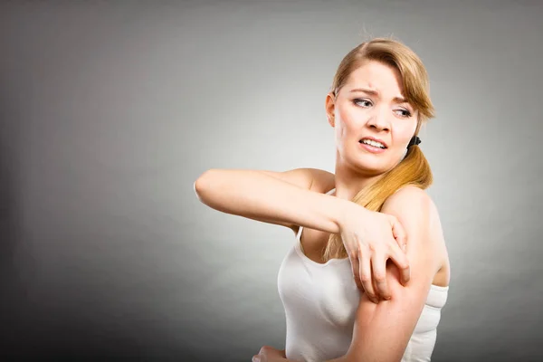 Frau kratzt sich mit allergischem Ausschlag am juckenden Arm — Stockfoto