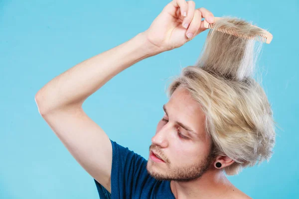 Hombre con corte de pelo elegante peinándose el pelo — Foto de Stock