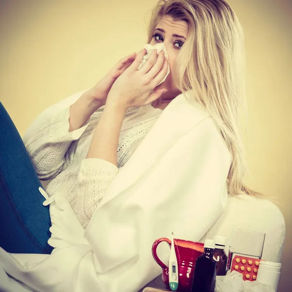 Mujer enferma teniendo gripe acostada en un sofá —  Fotos de Stock