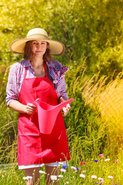 Mujer regando plantas en el jardín — Foto de Stock