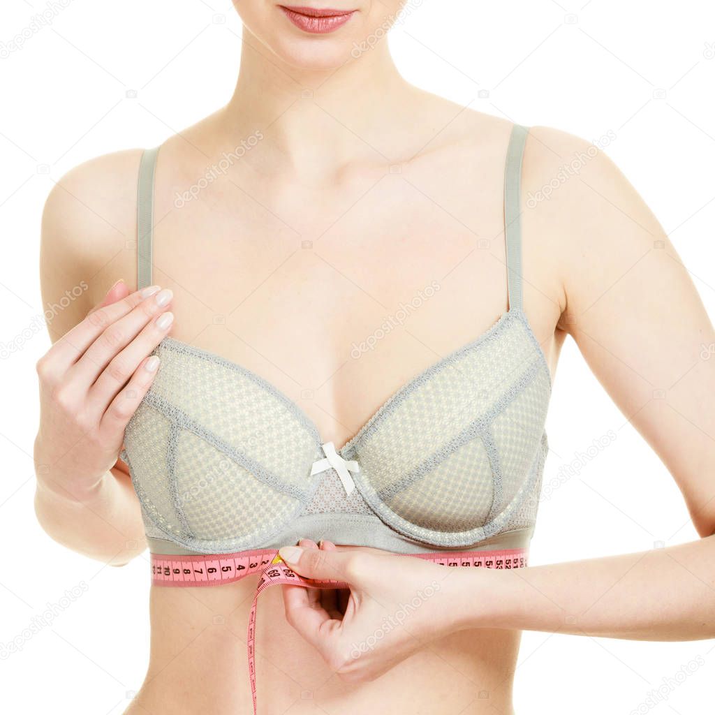 Woman measuring her under breasts.