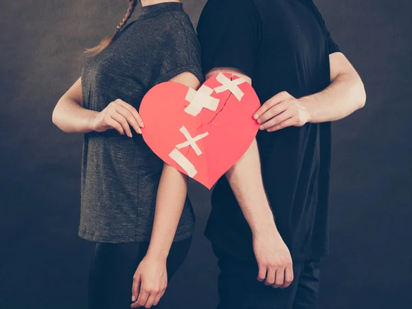 Las manos de hombre y mujer sostienen el corazón roto . — Foto de Stock