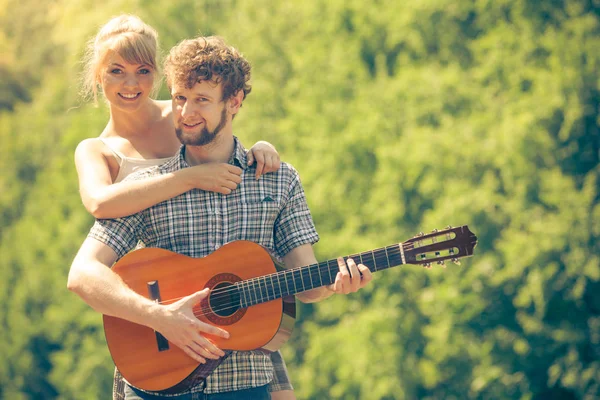 Giovane coppia campeggio suonare la chitarra all'aperto — Foto Stock