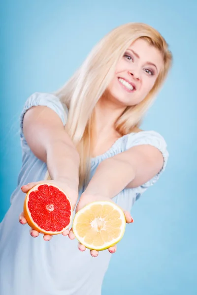 Женщина держит в руках цитрусовые грейпфруты — стоковое фото