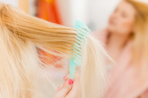 Mujer vestida con bata cepillándose el pelo — Foto de Stock