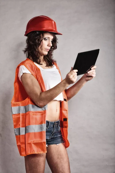 Chica sexy en casco de seguridad con tableta touchpad — Foto de Stock