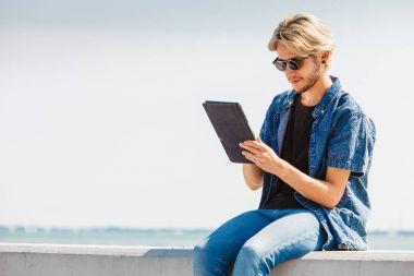 Onun tableti dışında kullanarak dışında sarışın adam