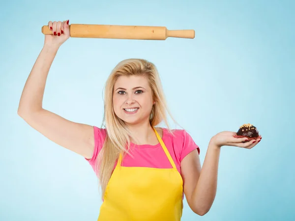 Mulher segurando cupcake e rolo pin vestindo avental — Fotografia de Stock