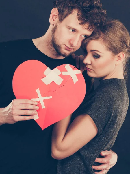 Triste pareja sostiene corazón roto . — Foto de Stock
