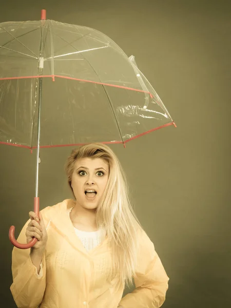 Mujer sosteniendo paraguas transparente mirando sorprendido — Foto de Stock